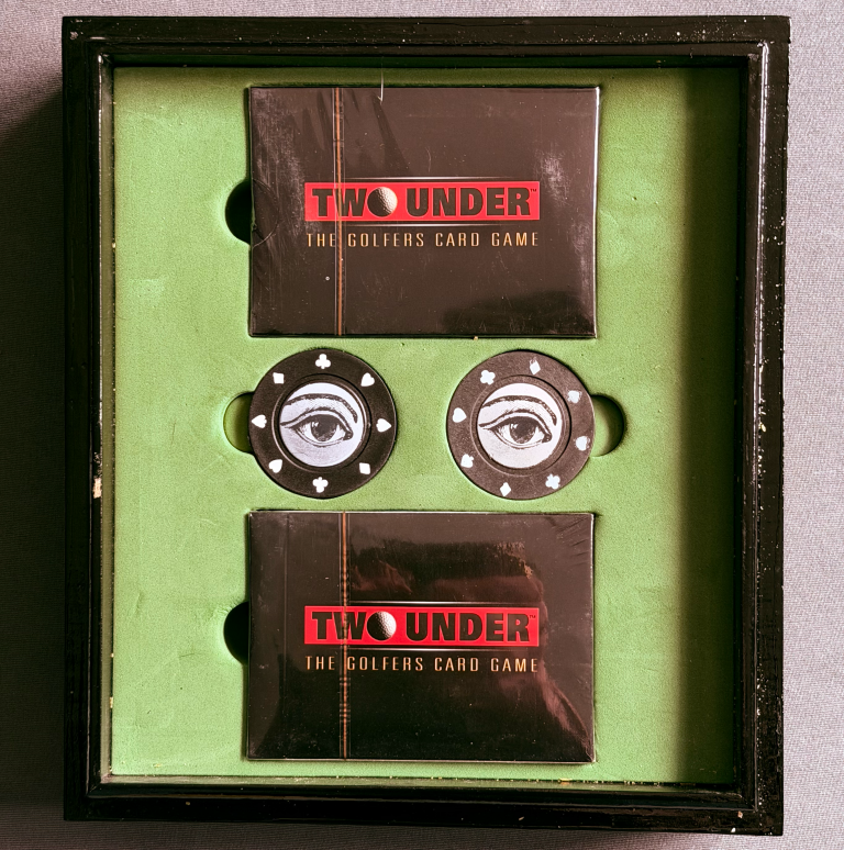 Inside the box of Two Under The Golfers Card Game with 2 decks of cards and 2 poker chips